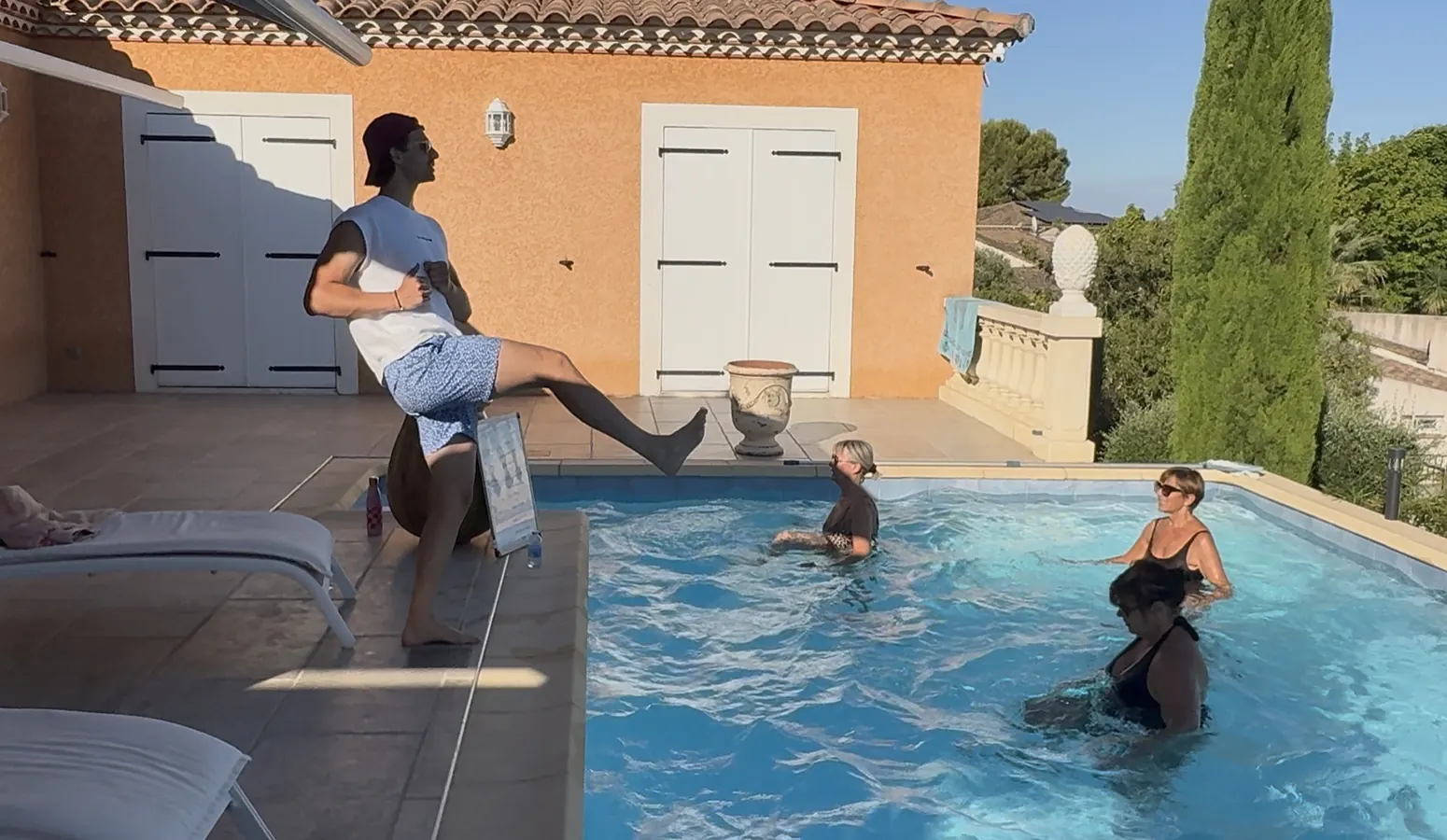 Clément accroupi au bord du bassin pendant le cours
