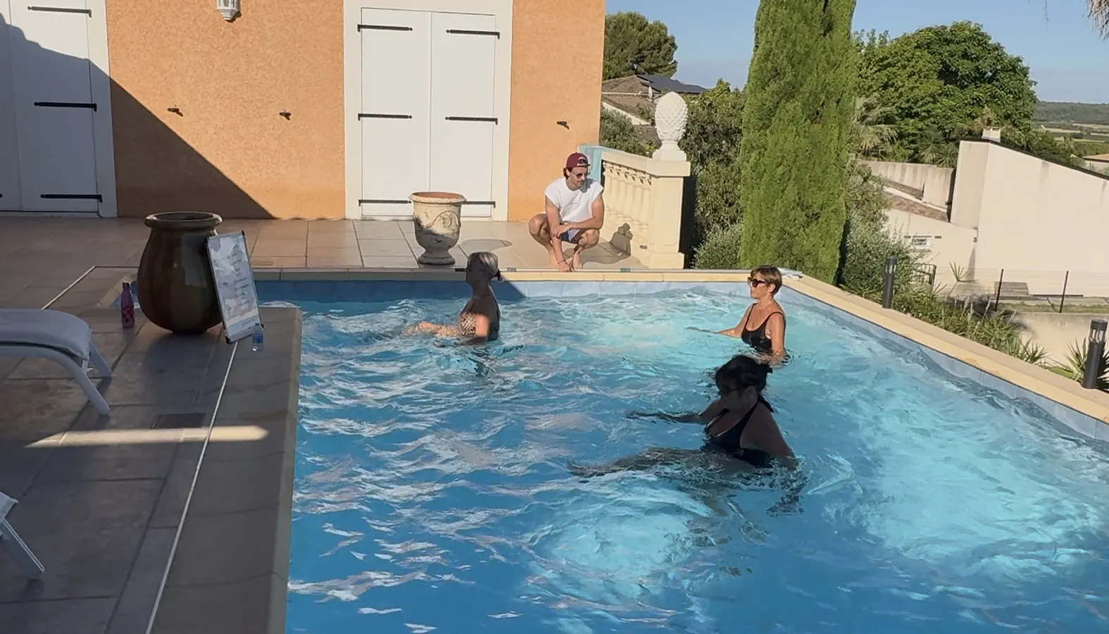 Clément accroupi au bord du bassin pendant le cours